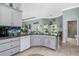 This kitchen features gray cabinets, granite counters, an island, and tiled backsplash at 185 Hercules Dr, Rotonda West, FL 33947
