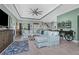 Comfortable living room with a plush sofa, ceiling fan, stylish decor, and a mounted television at 185 Hercules Dr, Rotonda West, FL 33947