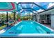Large, modern swim spa with a screened enclosure, surrounded by seating and grilling areas at 185 Hercules Dr, Rotonda West, FL 33947