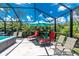 Screened-in pool area featuring a swim spa, lounge chairs, and a lush tropical backdrop, perfect for relaxation at 185 Hercules Dr, Rotonda West, FL 33947