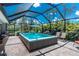 A screened-in pool with comfortable seating, umbrellas, and tropical landscaping at 185 Hercules Dr, Rotonda West, FL 33947