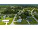An aerial view of the house in a neighborhood setting surrounded by wooded areas at 1865 Rival Ter, North Port, FL 34286