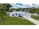A charming one-story home featuring a well-manicured lawn, and a two-car garage and flag at 1865 Rival Ter, North Port, FL 34286