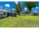 A sprawling backyard with lush green grass, storage shed, and a screened-in patio at 1865 Rival Ter, North Port, FL 34286