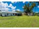 A sprawling backyard with lush green grass, storage shed, and a screened-in patio at 1865 Rival Ter, North Port, FL 34286