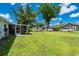 A sprawling backyard with lush green grass, storage shed, and a screened-in patio at 1865 Rival Ter, North Port, FL 34286