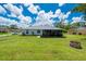 A sprawling backyard with lush green grass, storage shed, and a screened-in patio at 1865 Rival Ter, North Port, FL 34286