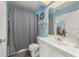 Well-lit bathroom with blue walls, a shower and tub combo, and a spacious single sink at 1865 Rival Ter, North Port, FL 34286