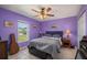 Cozy bedroom with a ceiling fan, window, and neutral-toned tile flooring at 1865 Rival Ter, North Port, FL 34286