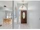 Bright foyer featuring a decorative front door, tiled floor, and modern pendant lighting at 1865 Rival Ter, North Port, FL 34286