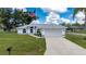 Beautiful one-story home featuring a well-manicured lawn, two-car garage, and an American flag at 1865 Rival Ter, North Port, FL 34286