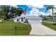 A beautiful one-story home featuring a well-manicured lawn, two-car garage, and American flag at 1865 Rival Ter, North Port, FL 34286