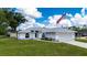 This is a nice one-story home with a well-manicured lawn, a two-car garage, and an American flag at 1865 Rival Ter, North Port, FL 34286