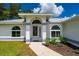 Charming home with an arched entryway, manicured lawn, and lush landscaping at 1865 Rival Ter, North Port, FL 34286