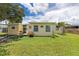 Expansive backyard featuring lush lawn and a charming view of the home's exterior at 22341 Midway Blvd, Port Charlotte, FL 33952