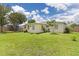 Large backyard with green grass surrounding a yellow home at 22341 Midway Blvd, Port Charlotte, FL 33952