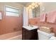 Pink tiled bathroom with vanity, toilet and shower/tub combination at 22341 Midway Blvd, Port Charlotte, FL 33952