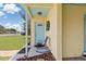 Inviting front porch, colorful door and a comfortable chair create a warm welcome at 22341 Midway Blvd, Port Charlotte, FL 33952