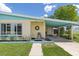 Close up of a charming covered porch with a rocking chair and well maintained lawn at 22341 Midway Blvd, Port Charlotte, FL 33952