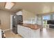 Kitchen island with storage, seating, and views into the living room with natural light at 22341 Midway Blvd, Port Charlotte, FL 33952