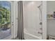 Bathroom tub and shower with white tile surround and a glass door that provides views and access to the outdoors at 25062 Palisade Rd, Punta Gorda, FL 33983