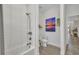 Bathroom featuring a tub and shower with white tile surround, toilet, and decorative artwork on the wall at 25062 Palisade Rd, Punta Gorda, FL 33983