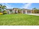 Attractive single-story home with a manicured lawn and landscaping, and a three-car garage at 25062 Palisade Rd, Punta Gorda, FL 33983