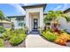 Inviting front entrance showcasing lush landscaping and a modern design with a decorative wreath at 25062 Palisade Rd, Punta Gorda, FL 33983
