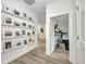 Hallway featuring art displays, leading to exercise room and kitchen beyond at 25062 Palisade Rd, Punta Gorda, FL 33983