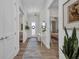 Bright hallway with wood flooring, a decorative rug, console table, and views into the adjacent rooms at 25062 Palisade Rd, Punta Gorda, FL 33983