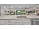 Kitchen island sink with quartz countertops, stainless steel appliances, and a view to living and dining spaces at 25062 Palisade Rd, Punta Gorda, FL 33983