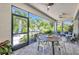 Covered lanai offering comfortable seating, a dining table, and serene views of the landscaped backyard at 25062 Palisade Rd, Punta Gorda, FL 33983