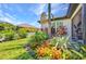 Lush garden bed of vibrant foliage, including bromeliads and palms, adorns the home's exterior, enhancing its curb appeal at 25062 Palisade Rd, Punta Gorda, FL 33983