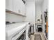 A well-organized laundry room featuring a washer, dryer, upper cabinets, and ample storage space at 25062 Palisade Rd, Punta Gorda, FL 33983