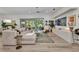 Bright, open living room features a modern sectional sofa and views of the outdoor living space at 25062 Palisade Rd, Punta Gorda, FL 33983