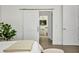 Bedroom with barn door opening to ensuite bathroom; light floors, neutral color scheme at 25062 Palisade Rd, Punta Gorda, FL 33983