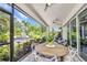 Outdoor patio with dining table and a view of a tropical outdoor lounge area with a fire pit at 25062 Palisade Rd, Punta Gorda, FL 33983