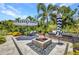 Outdoor patio with built-in seating around a fire pit perfect for entertaining and relaxation in the tropical landscaped backyard at 25062 Palisade Rd, Punta Gorda, FL 33983