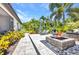 This luxurious backyard features a cozy fire pit, comfortable lounge chairs and lush landscaping perfect for entertaining guests at 25062 Palisade Rd, Punta Gorda, FL 33983