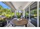 Covered patio with ceiling fan and outdoor table with surrounding views of lush landscape at 25062 Palisade Rd, Punta Gorda, FL 33983