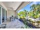 Covered patio with dining table and seating overlooking backyard firepit and lush landscaping at 25062 Palisade Rd, Punta Gorda, FL 33983