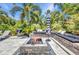 An inviting outdoor space with built-in seating, a fire pit, a grill and tropical landscaping offers the perfect place to relax at 25062 Palisade Rd, Punta Gorda, FL 33983