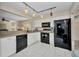 Clean kitchen with white cabinets and black appliances offering modern convenience and style at 26336 Nadir Rd # 10, Punta Gorda, FL 33983