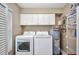 Functional laundry room with washer, dryer, storage cabinets and hot water heater at 26336 Nadir Rd # 10, Punta Gorda, FL 33983