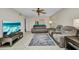 Comfortable living room featuring tile floors, fan, and gray reclining sofa set with throw rug at 26336 Nadir Rd # 10, Punta Gorda, FL 33983