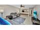 Comfortable living room featuring tile floors, fan, and gray reclining sofa set with throw rug at 26336 Nadir Rd # 10, Punta Gorda, FL 33983