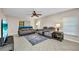 Comfortable living room featuring tile floors, fan, and gray reclining sofa set with throw rug at 26336 Nadir Rd # 10, Punta Gorda, FL 33983