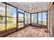 Enclosed patio featuring tiled floor, ceiling fan and wall of windows with views to yard at 26336 Nadir Rd # 10, Punta Gorda, FL 33983