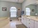 Bright bathroom featuring double windows, marble-top vanity, soaking tub and tile flooring at 2969 Wells Ave, North Port, FL 34286
