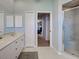 Spacious bathroom featuring a glass enclosed shower, double marble-top vanity, and a doorway to bedroom at 2969 Wells Ave, North Port, FL 34286